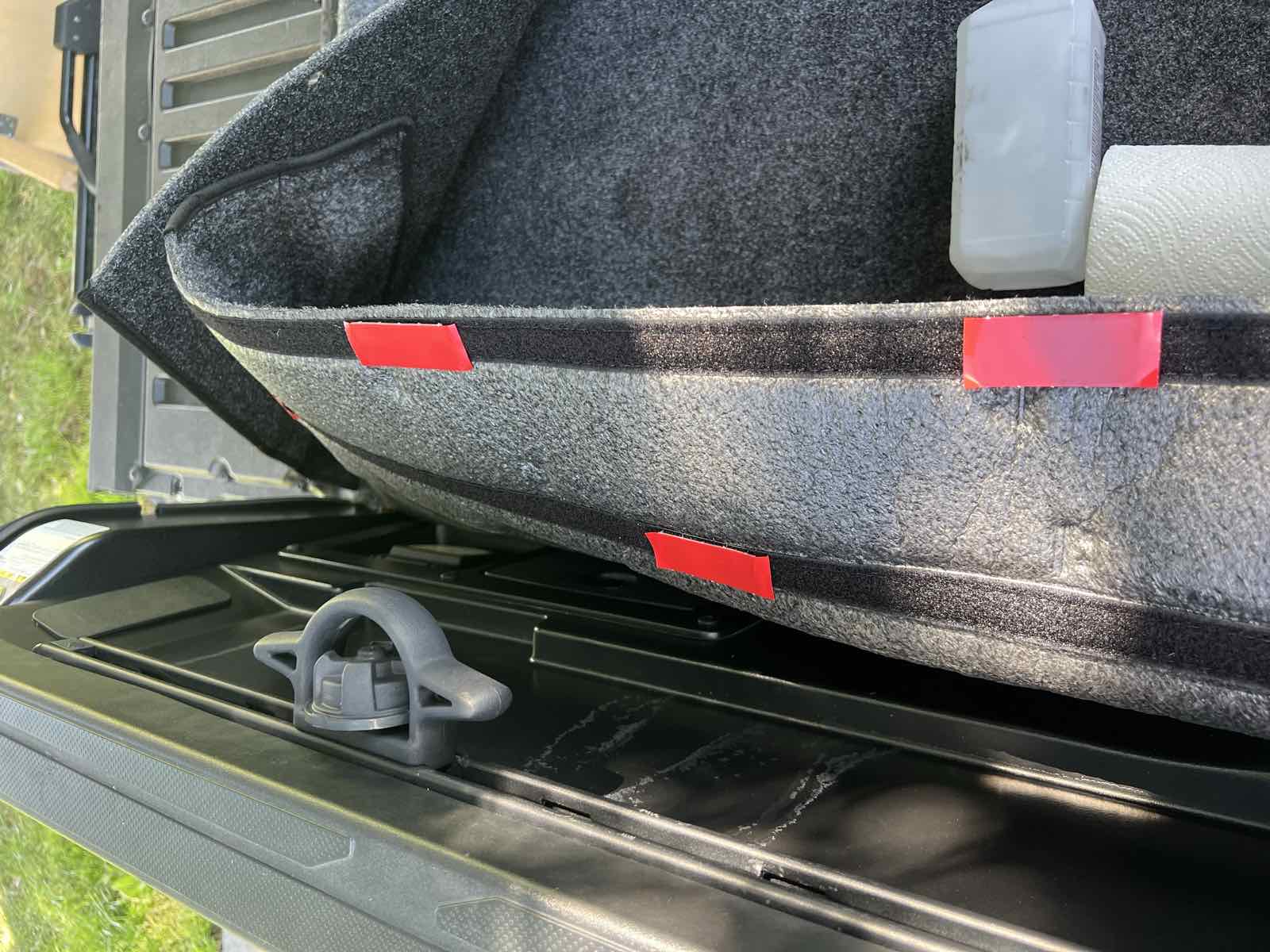 Close-up of the bed liner's upper edge meeting the underside of a Tacoma bed rail, showing that the liner runs to the rail rather than tucking beneath it.
